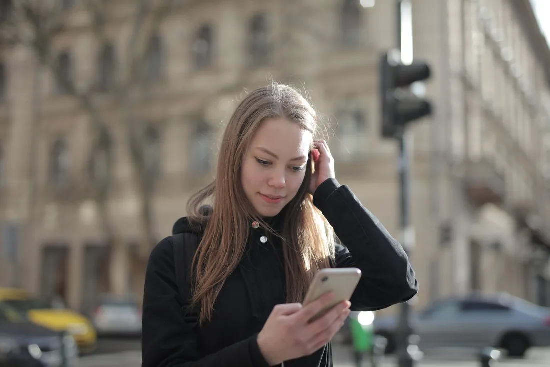 Woman checking her phone on a city street
